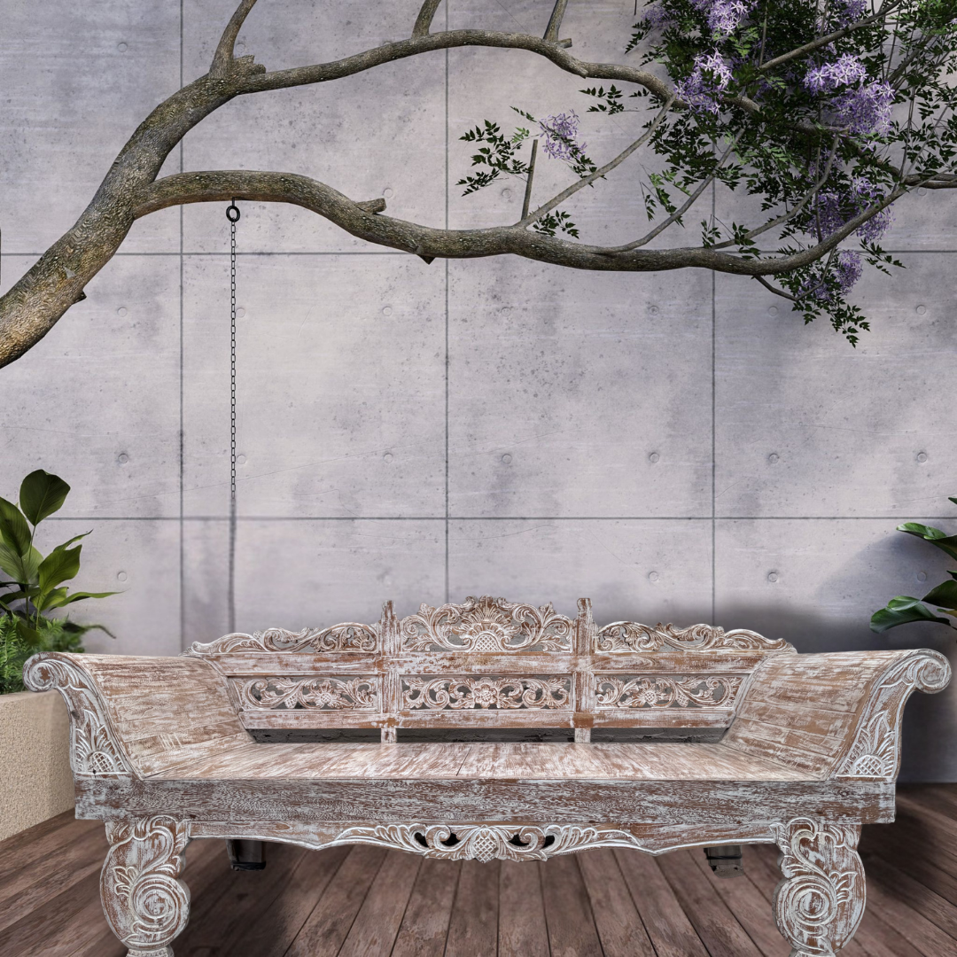 Decorative wooden bench with intricate carvings against a gray tiled wall.