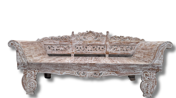 Carved wooden bench with intricate patterns on a white background