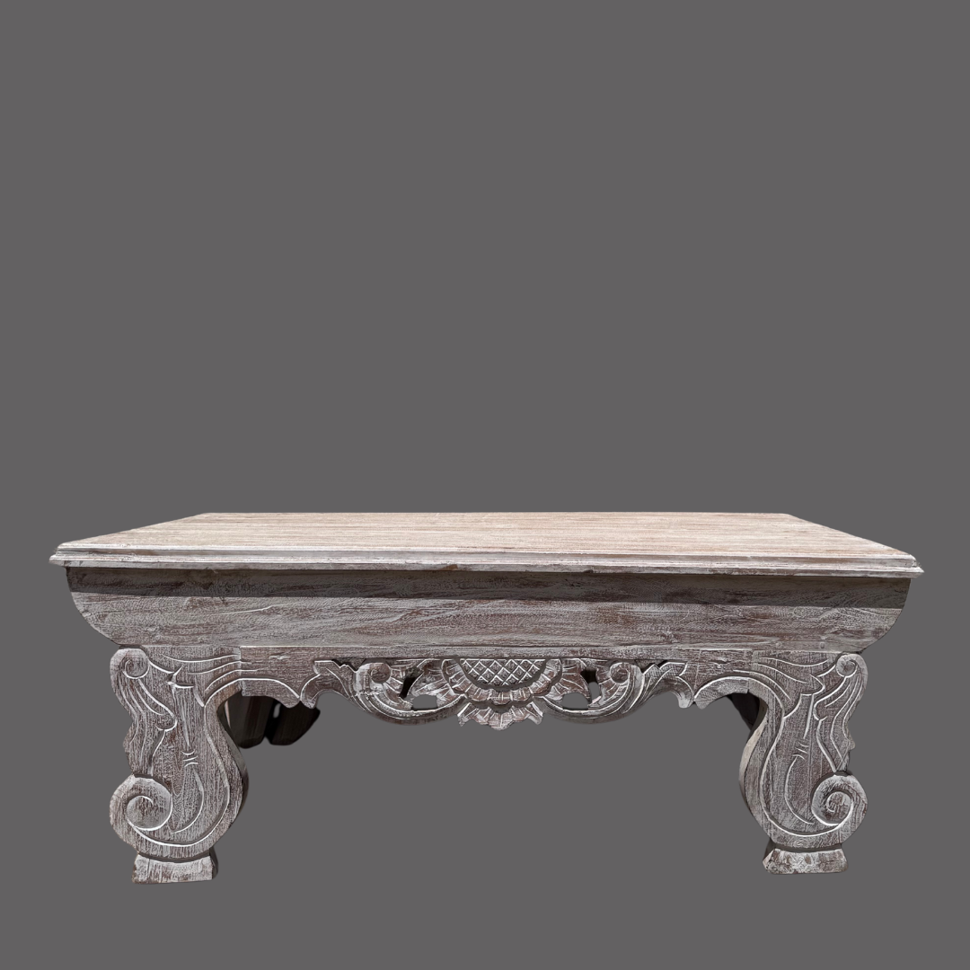 Decorative wooden table with intricate carvings on a gray background