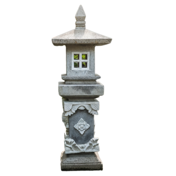 Concrete pagoda lantern with warm candlelight glowing through four-pane window and carved floral detail on pedestal