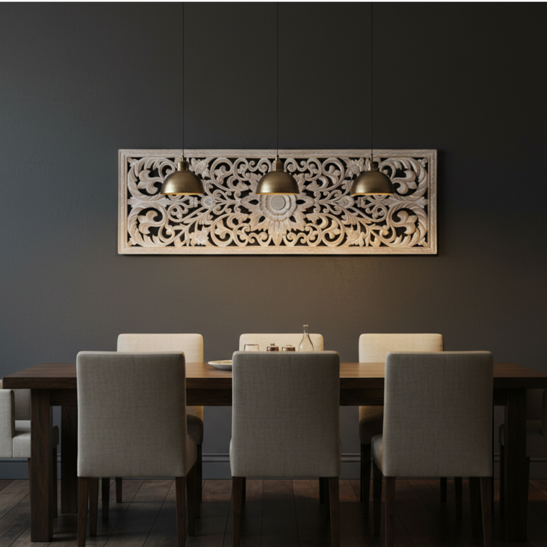 
Whitewash precision-cut MDF wall art panel with Balinese floral scroll design hung on a deep charcoal feature wall above a long dark dining table with cream upholstered chairs and three gold dome pendant lights

