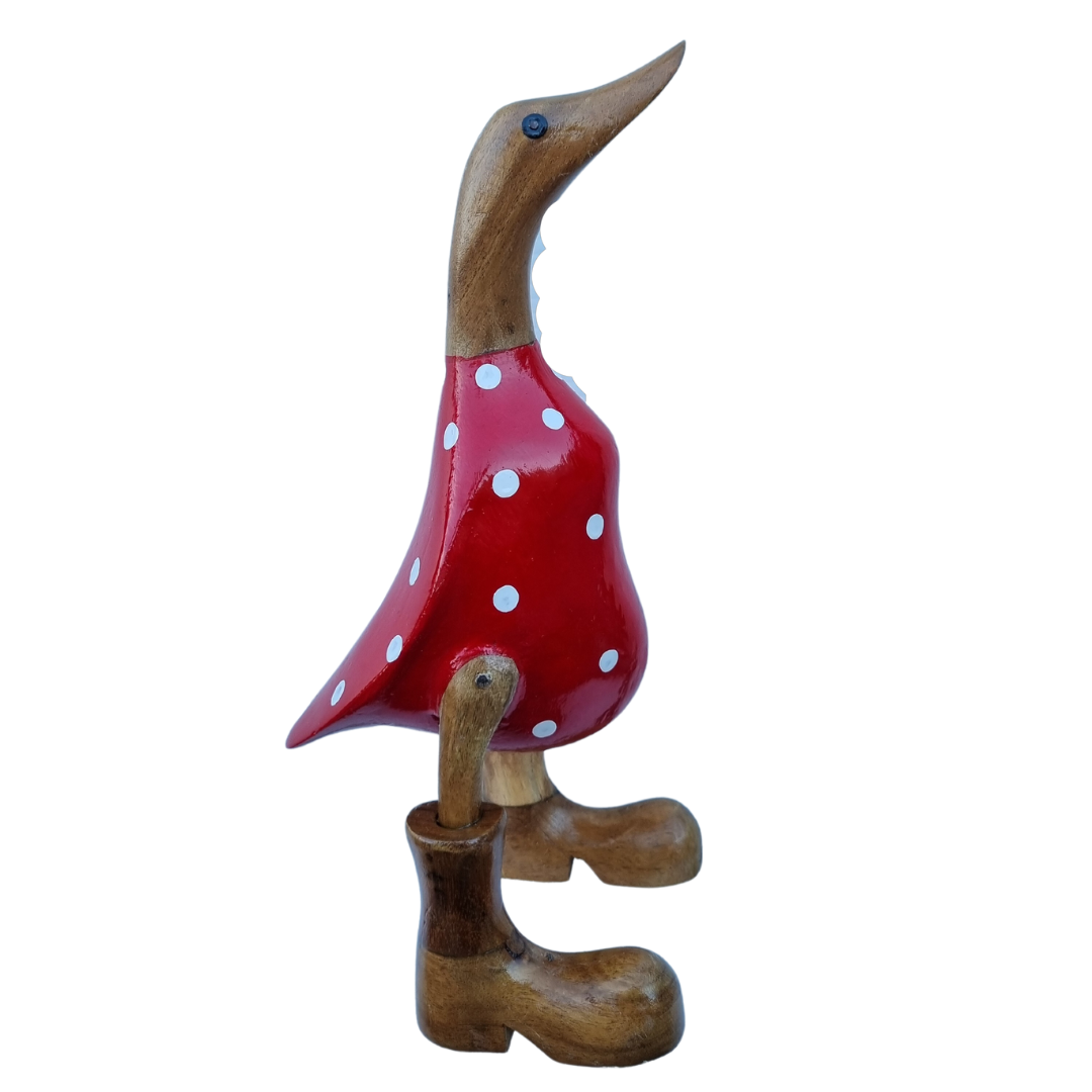 Side view of a white polka-dot design with a glossy scarlet finish, natural timber head and brown boots