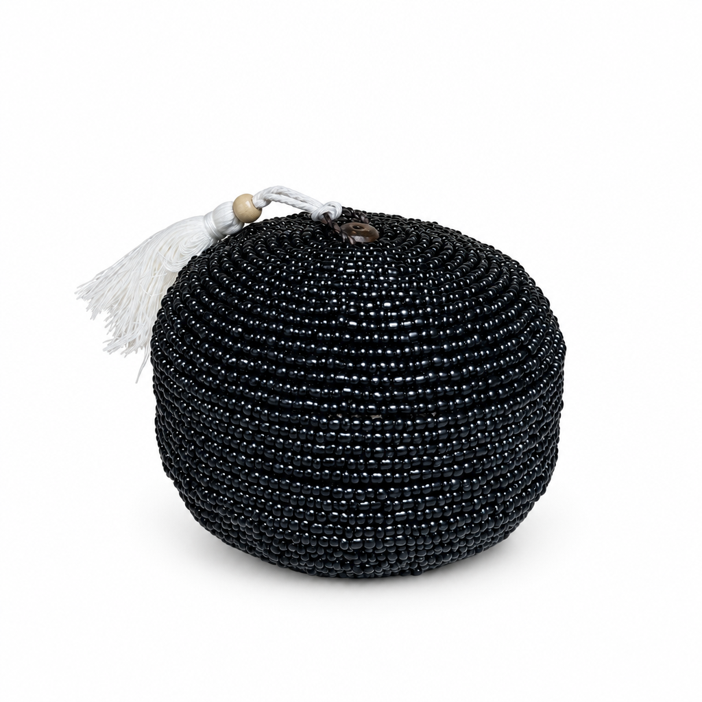 Black round beaded piece on a white background