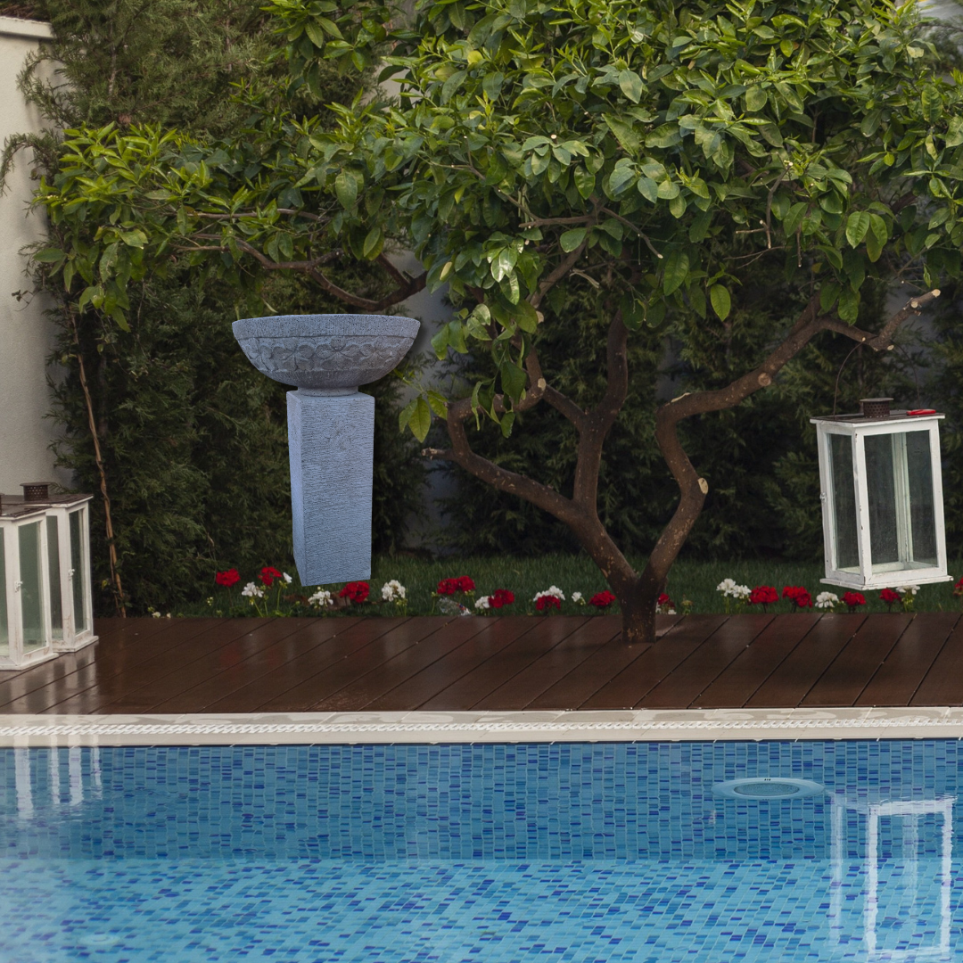 Pool area with a wooden deck, garden, and decorative elements.