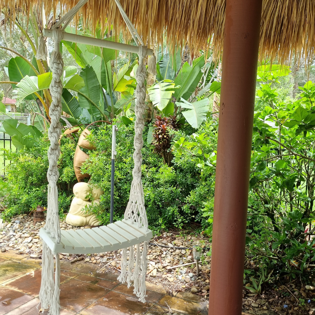 Balinese style garden with a white wooden swing 