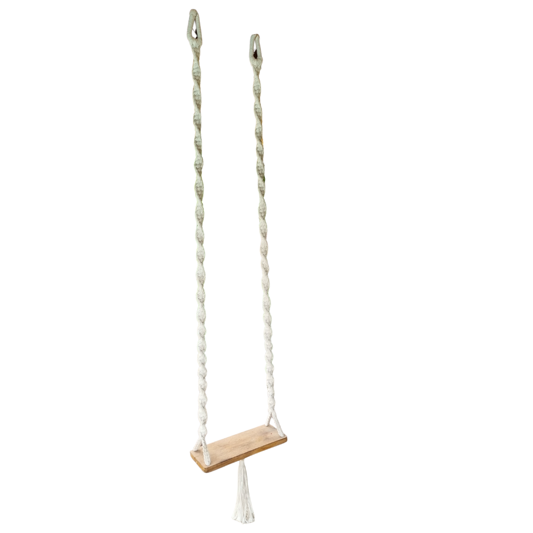 A handcrafted Balinese style white macrame swing with a solid wooden seat, designed with intricate patterns and tassels.