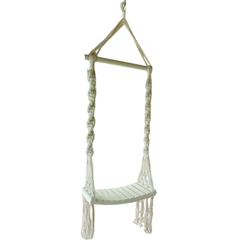 A handcrafted Balinese style white macrame swing with a solid wooden seat, designed with intricate patterns and tassels.