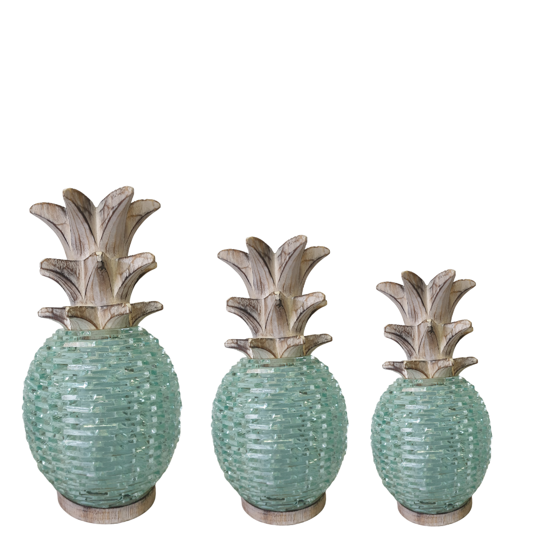 Three sizes of Boho Glass Pineapple Décor displayed together — large, medium and small — showing the aqua sea-glass mosaic textured body and whitewashed carved wooden leaf top of each, handcrafted tropical boho tabletop sculpture by Azure Decor