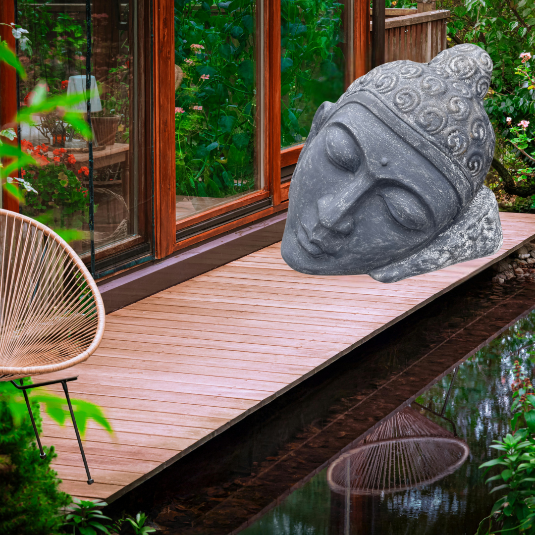 Buddha statue on a wooden deck by a pond with a blurred garden background