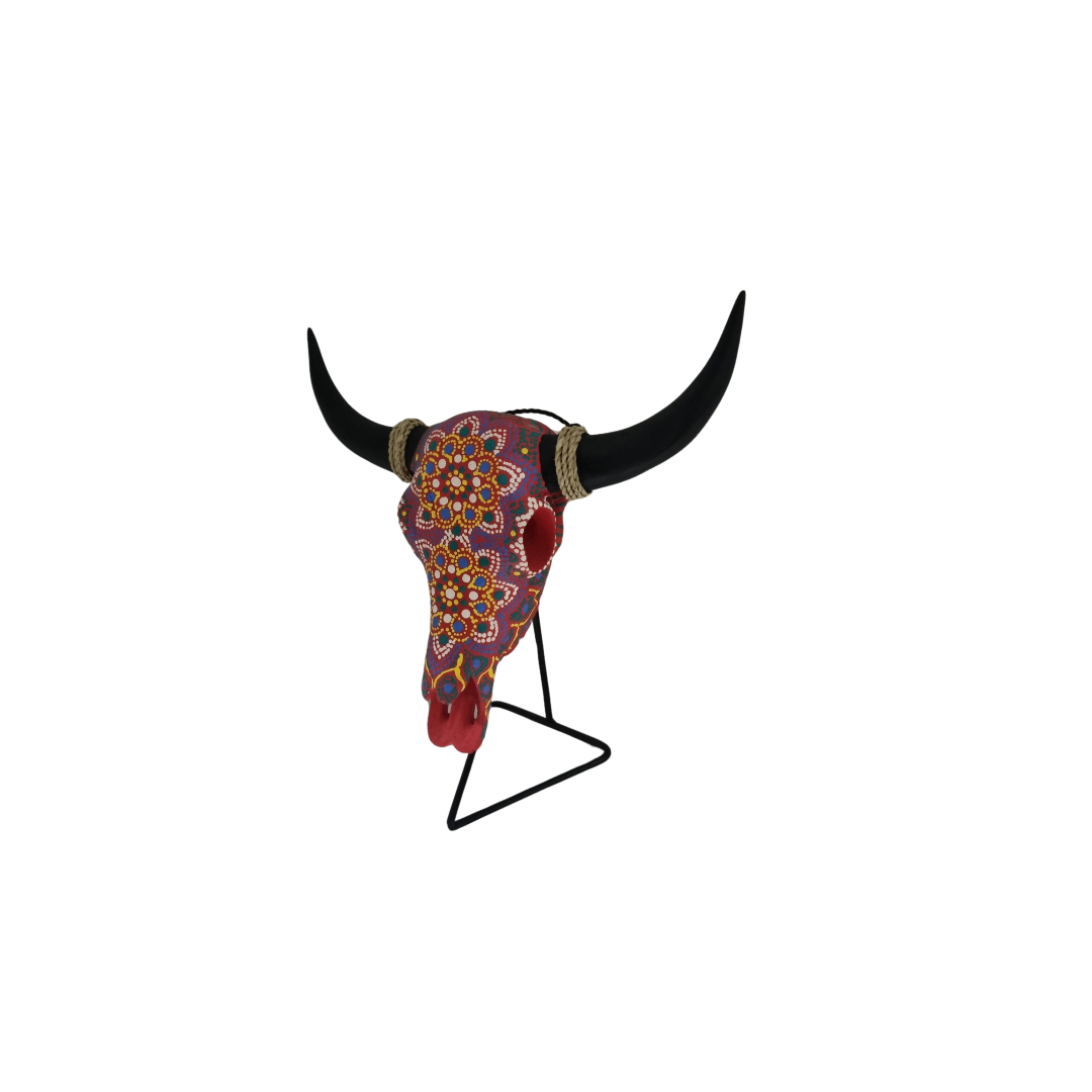 Vivid Tribal Bull Skull – hand-painted resin bull skull with bold multicolour dot mandala floral pattern in purple, red, yellow and teal on black metal triangle stand, white background