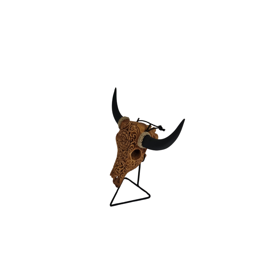 Celestial Flora Skull – hand-painted resin bull skull with intricate raised warm tan and brown floral scroll carving covering skull, black horns with jute rope and cord accents on black metal triangle stand, white background
