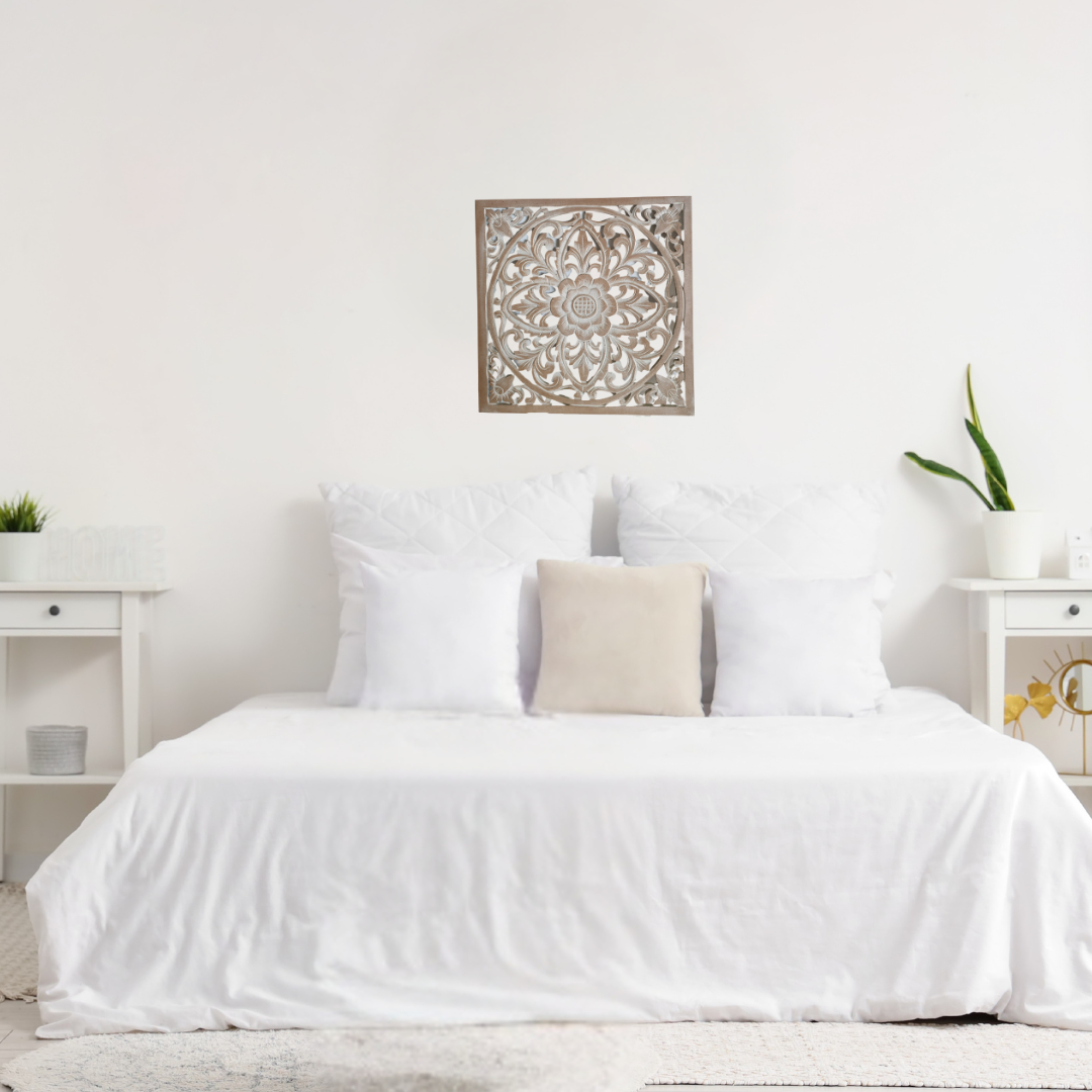 Neatly made bed with white bedding and pillows in a room with decorative wall art.