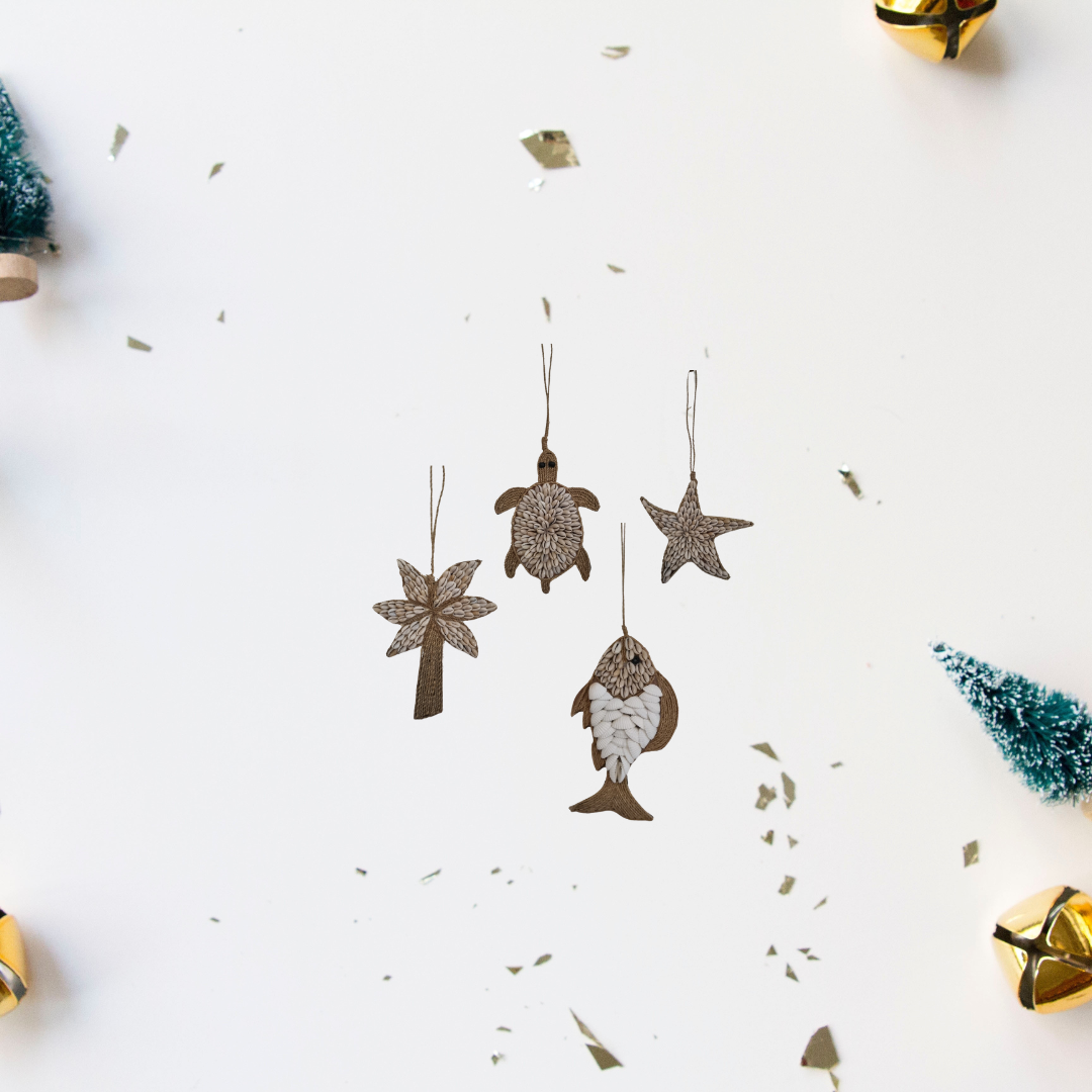 A collection of decorative garlands with sea-inspired designs including representations of fish, turtles, palm trees, and starfish, laid out on a white surface.