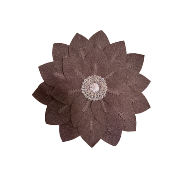 Flower-shaped woven wall piece with a shell centre detail on a white background