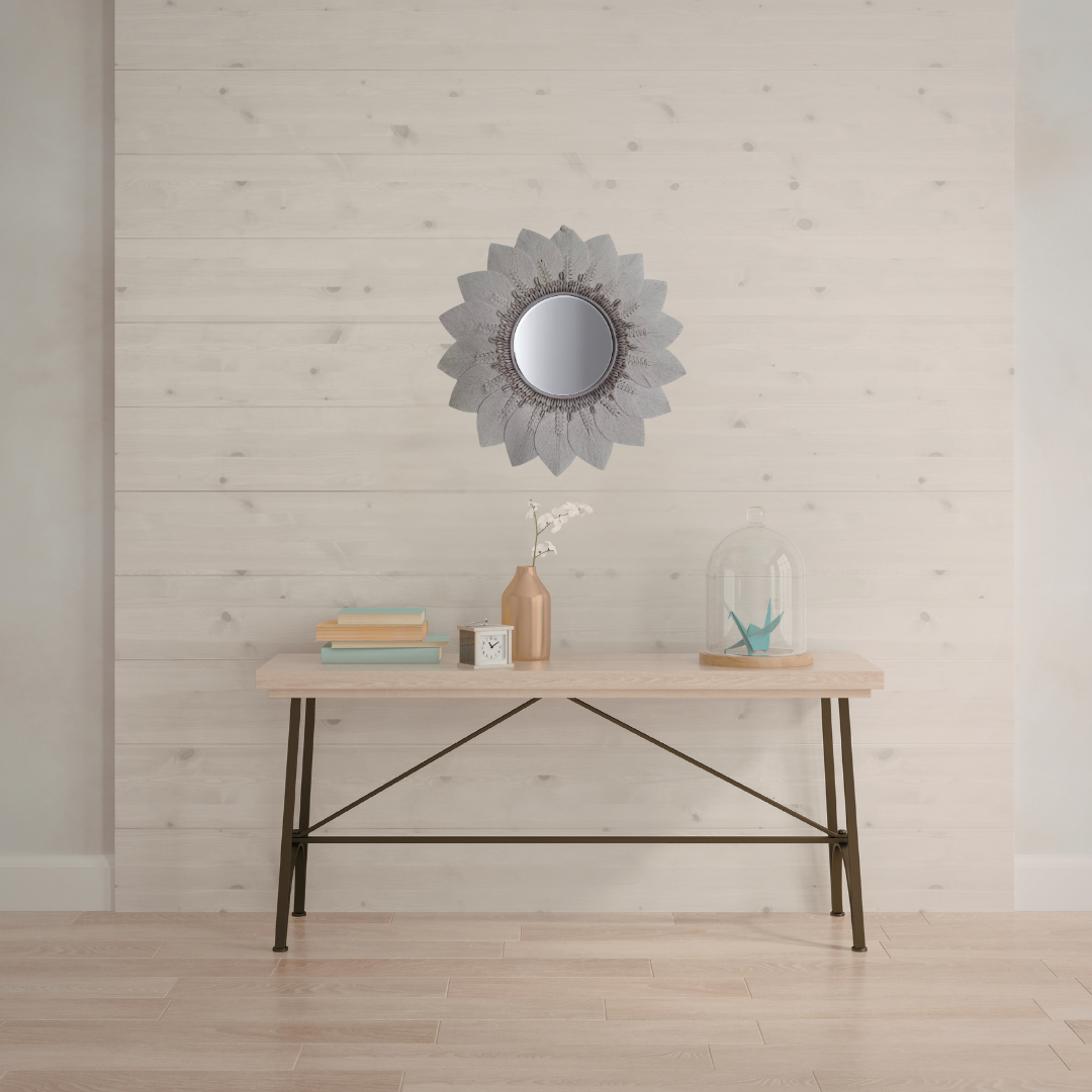 Wooden desk with decorative items against a light wooden paneled wall.