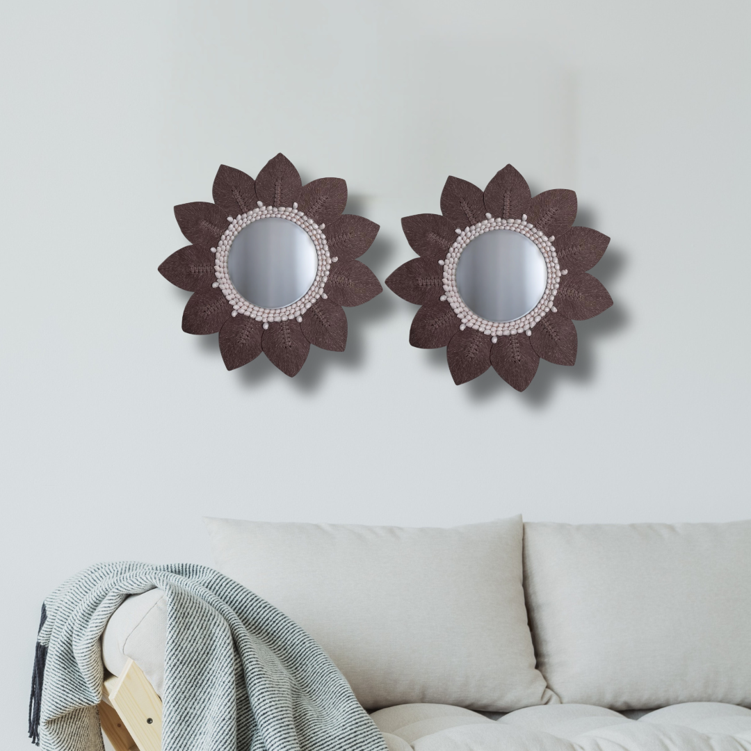 Two floral wall mirrors above a beige sofa, featuring a brown macramé leaf mirror with shell bead detail, boho coastal décor Australia.
