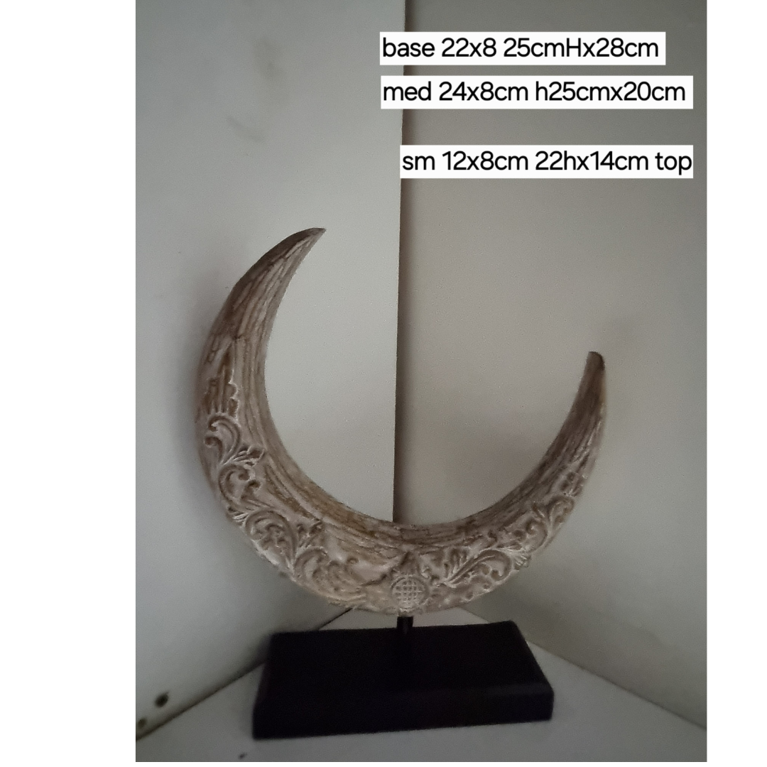 A crescent moon-shaped wooden decoration piece with a rustic brown wash finish, mounted on a flat base.