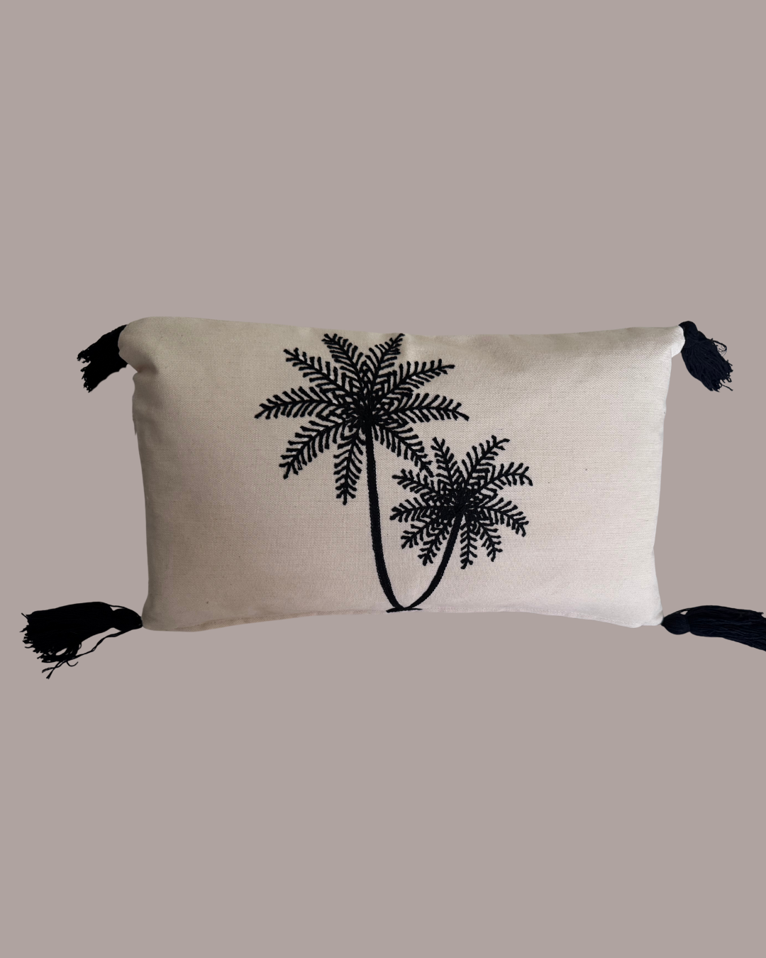 Beige pillow with black palm tree design on a beige background