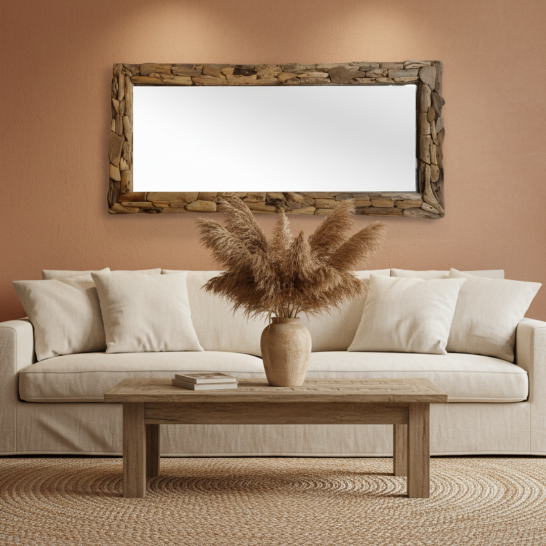 Large rectangular driftwood wall mirror styled above a linen sofa in a warm coastal living room with pampas grass in a ceramic vase and timber coffee table