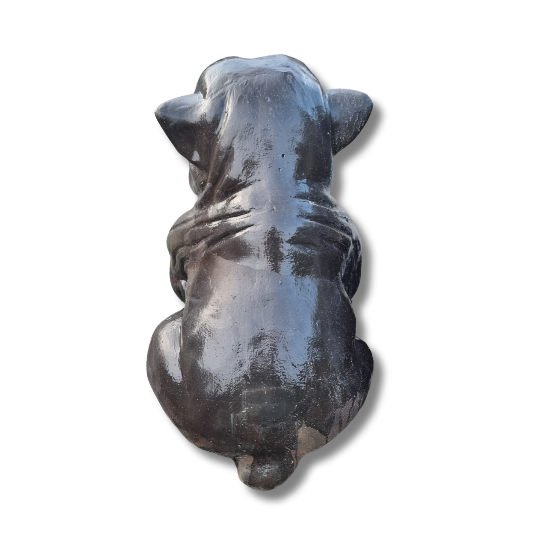 Black stone sculpture of a dog on a white background