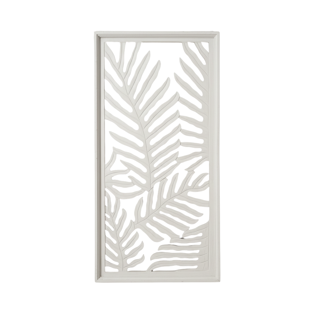 White painted fern leaf carved wall panel leaning against grey wall, studio shot