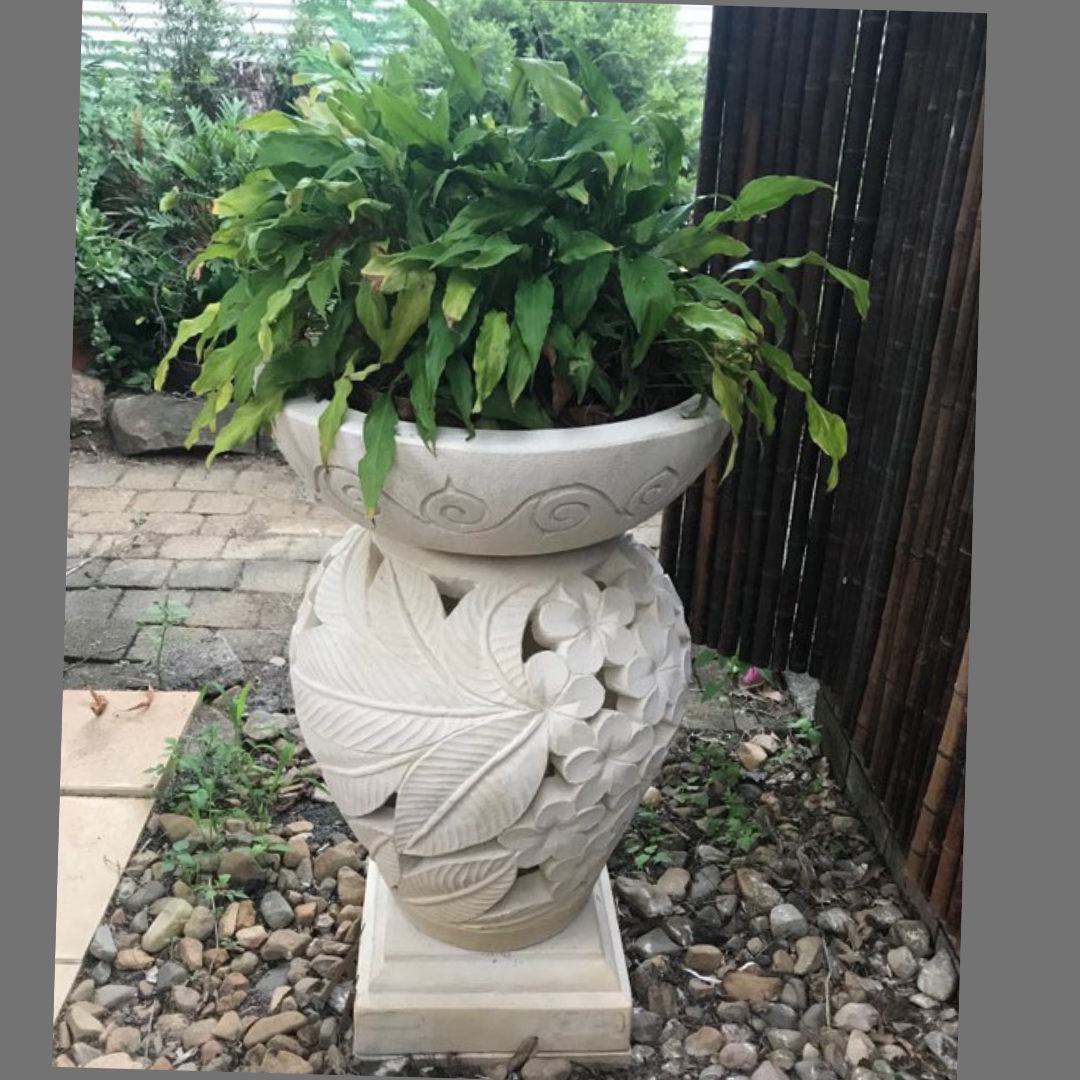 Decorative  planter with a potted plant on a garden setting