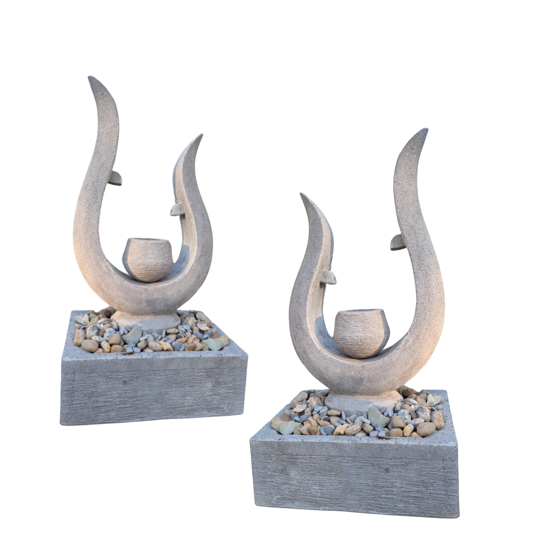 Two stone sculptures with curved designs on a white background