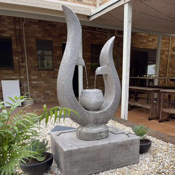 Decorative stone fountain with water feature in a garden setting