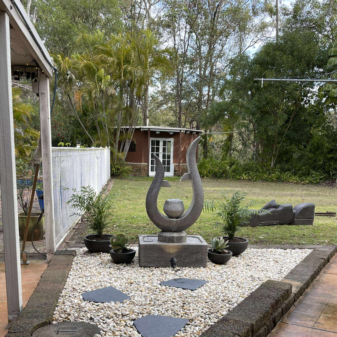 Outdoor garden with a decorative stone sculpture and plants