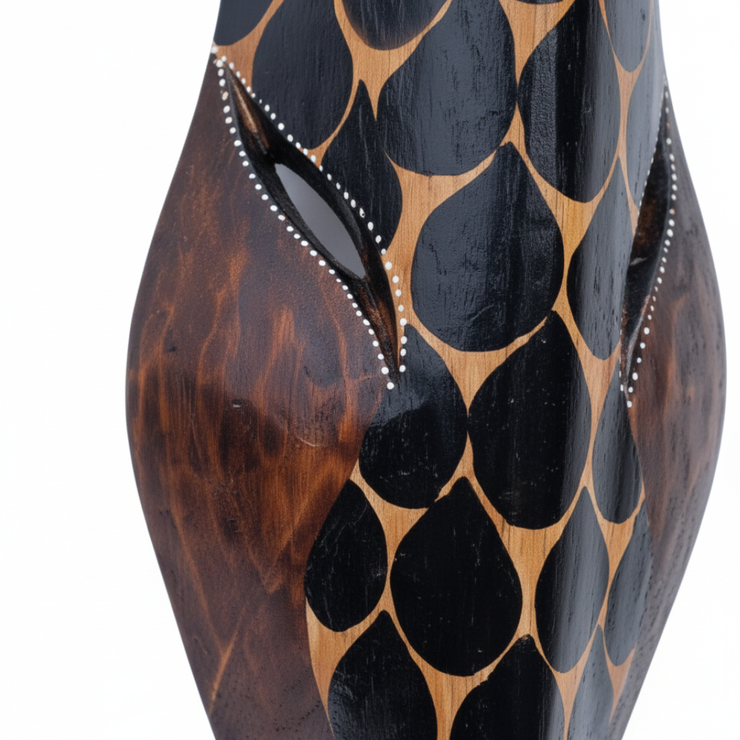 Close-up of hand-carved black spot pattern on dark timber giraffe mask showing wood grain and craftsmanship detail
