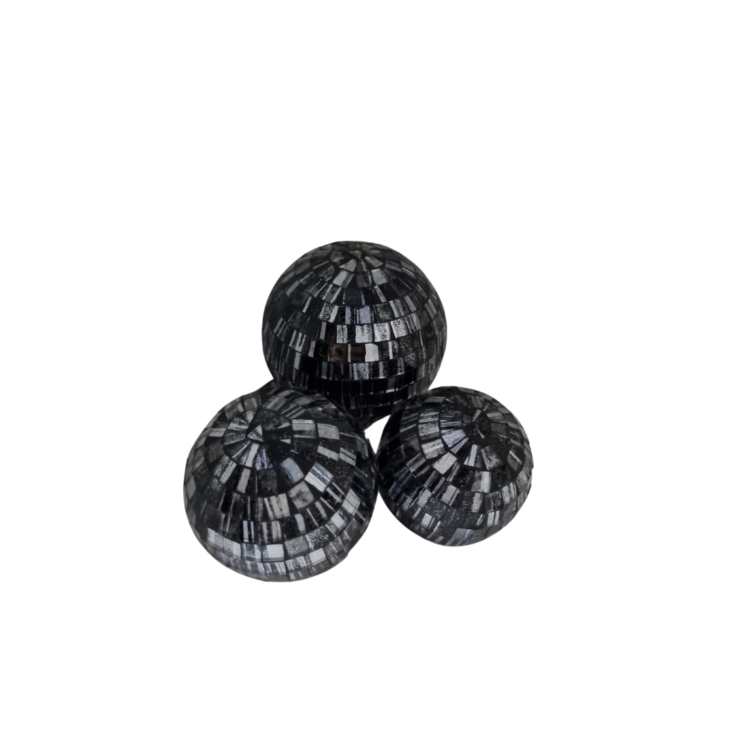 "Three dark silver mosaic glass spheres grouped together on a white background