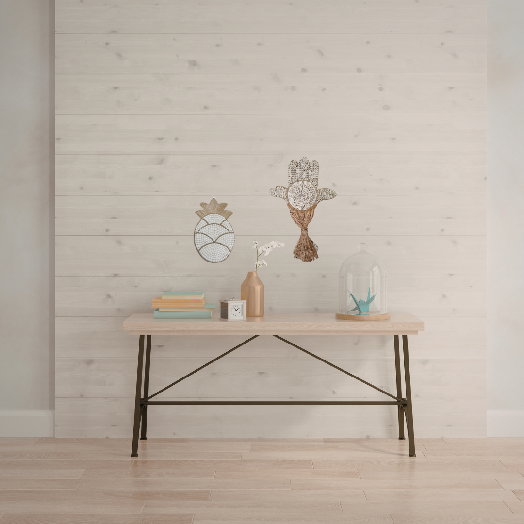 Wooden desk with decorative items against a light wooden paneled wall.