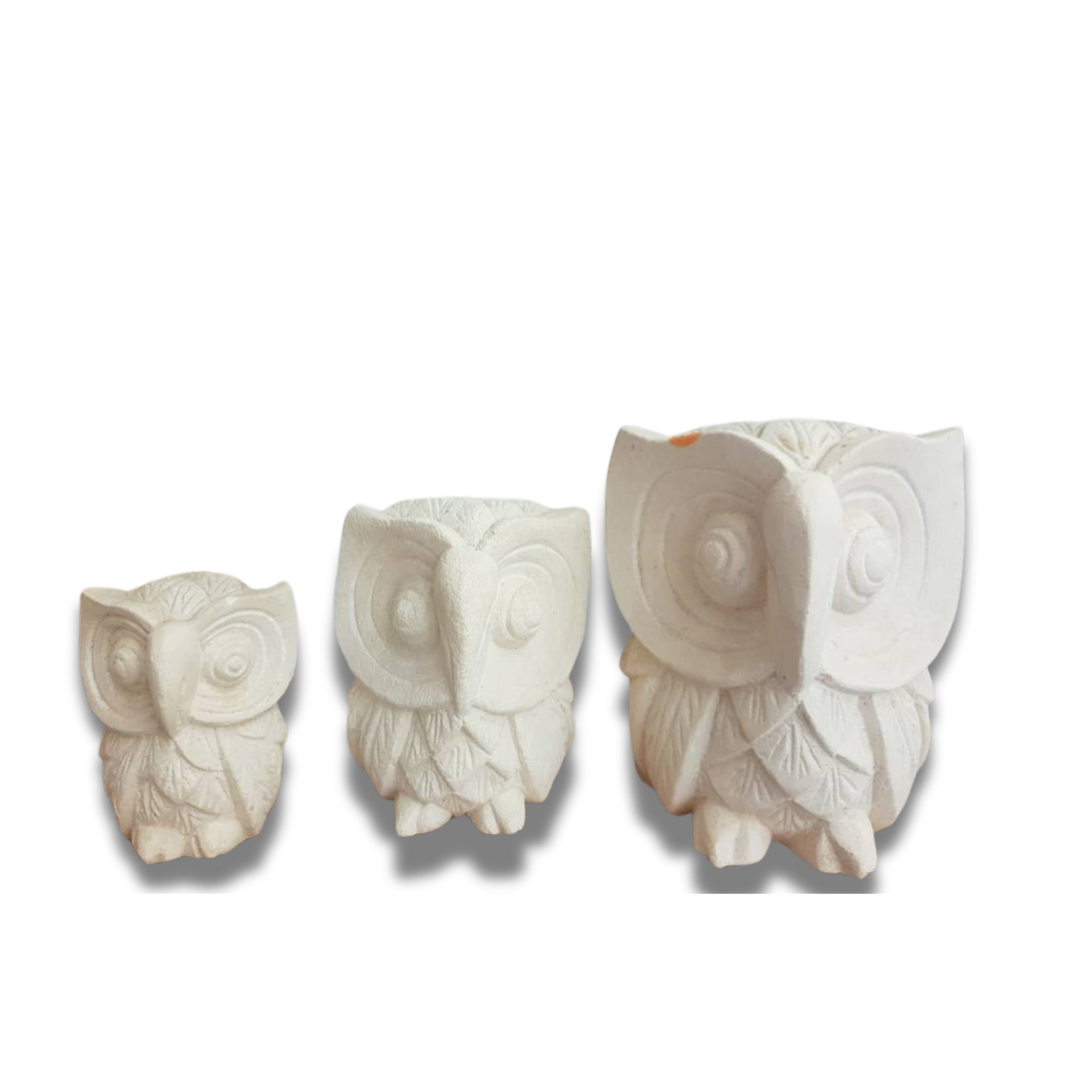 A set of three limestone carvings of owls in decreasing size order, from largest to smallest, with a plain background.