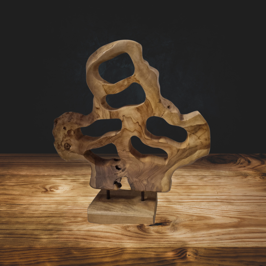 Handcrafted teak wood table top sculpture with abstract open carving, styled on a timber surface with warm dramatic lighting against a dark background