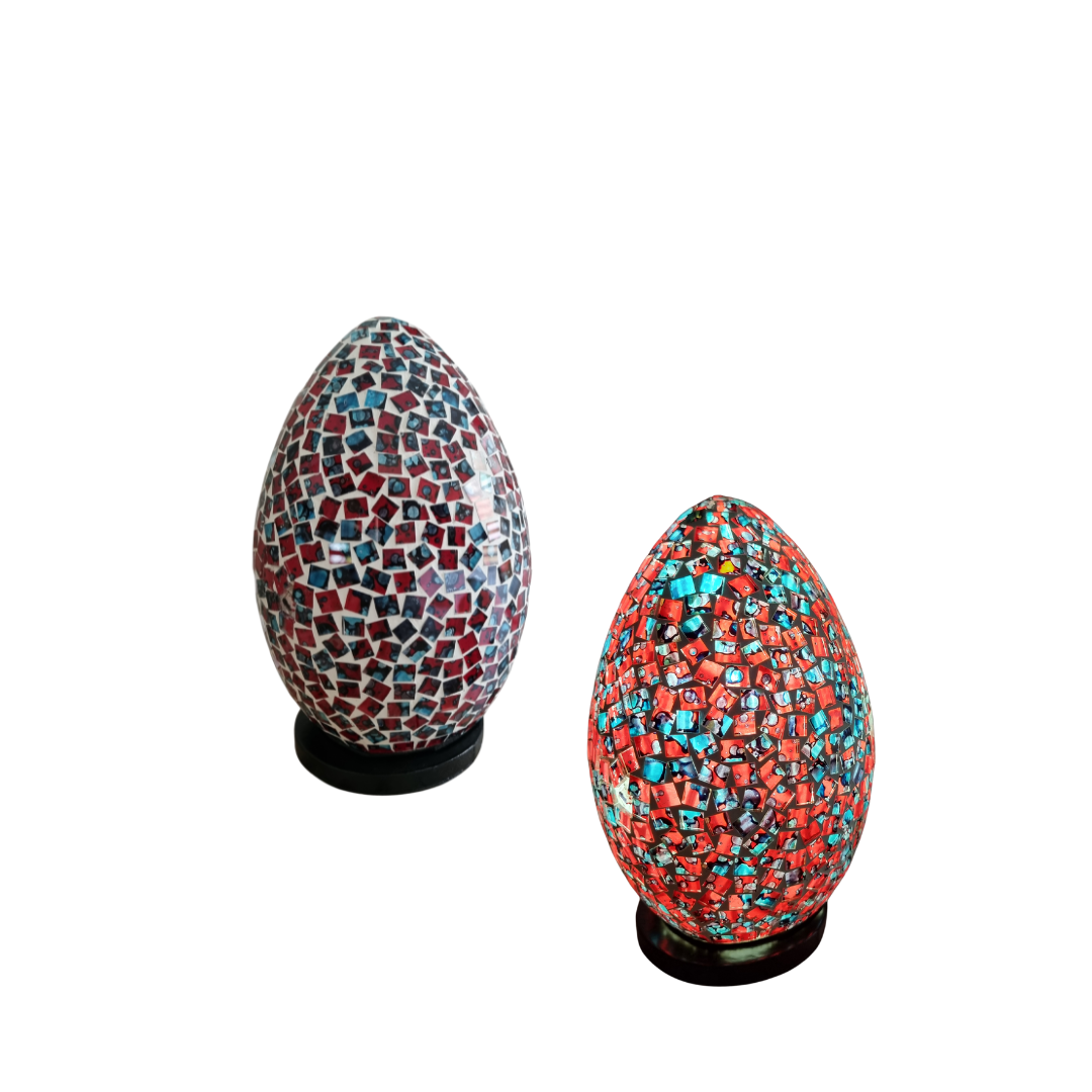 Two unlit mosaic oval lamps on dark bases — left lamp in deep red and teal hand-cut glass tiles, right lamp in bold red and turquoise mosaic glass, on a white background