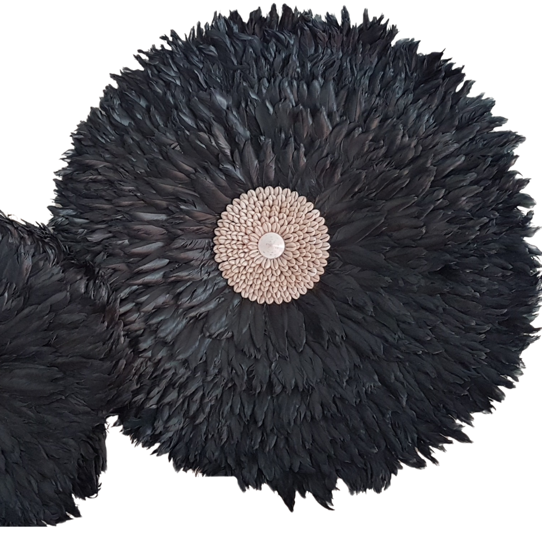 Close-up of two large black handcrafted JUJU Hats with cowrie shell and mother of pearl centres, showing feather texture detail — boho feather wall art in black