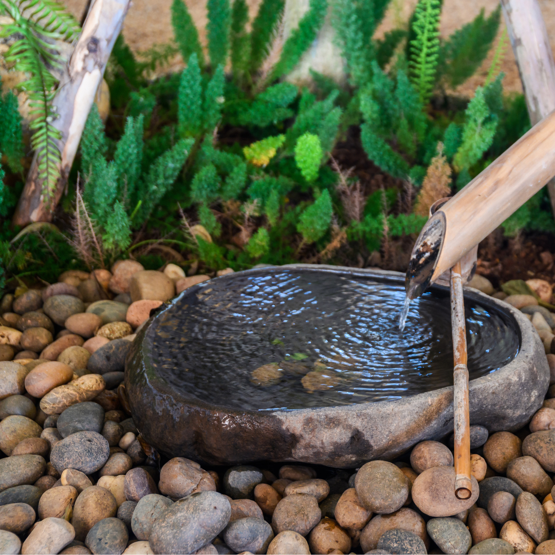 Japanese stone garden basin displayed in a lush Japanese-style garden setting with Zen decor