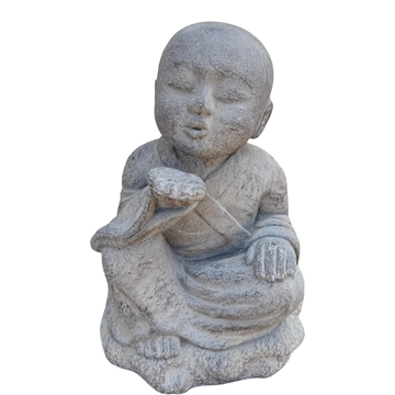 Grey kiss-blowing monk statue seated with one palm raised near its lips and a weathered textured finish