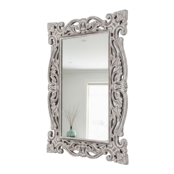 Decorative mirror with intricate silver frame on a white background
