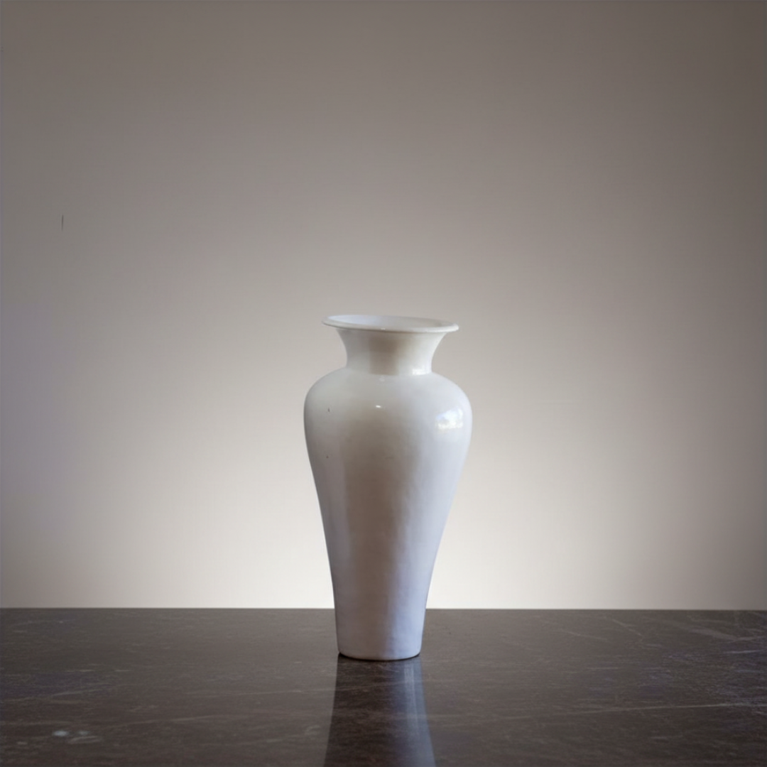 White vase on a dark surface with a plain background