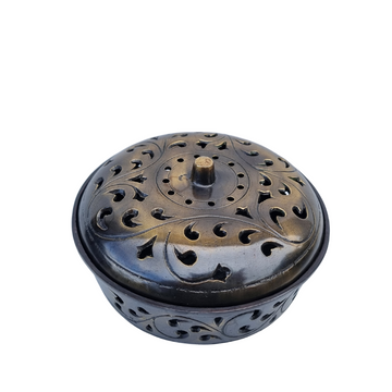 A bronze metal mosquito coil holder with intricate designs, crafted from strong steel, with a round shape and a lid.