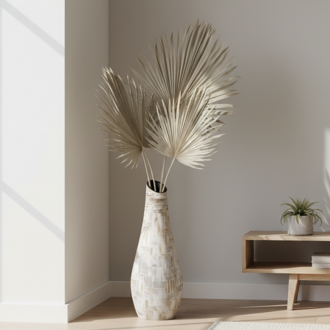Terracotta mosaic vase with dried palm stems in a light, minimalist living space