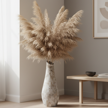Tall terracotta patchwork vase with white pampas grass styled against a neutral wall