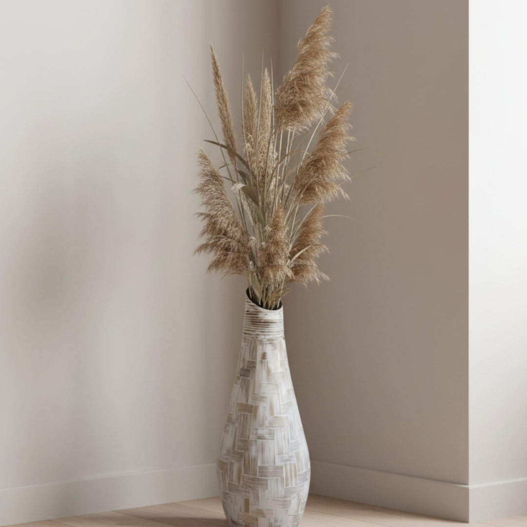 Decorative vase with pampas grass against a plain wall