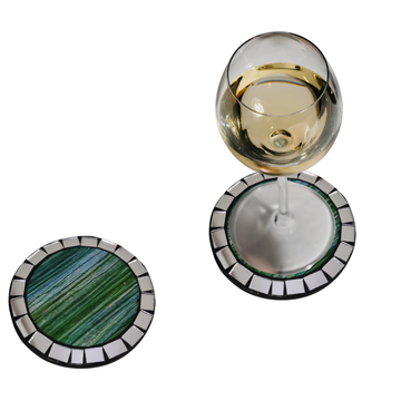 A set of round mosaic drink coasters in various colors, displayed alongside glasses of white wine and an assortment of food items.