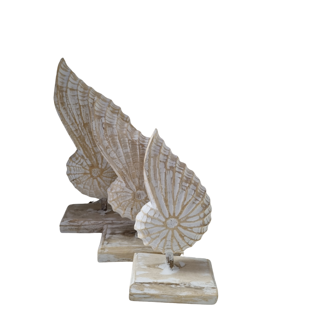 A handcrafted wooden conch shell decoration on a stand, with a natural white  wash white back drop 