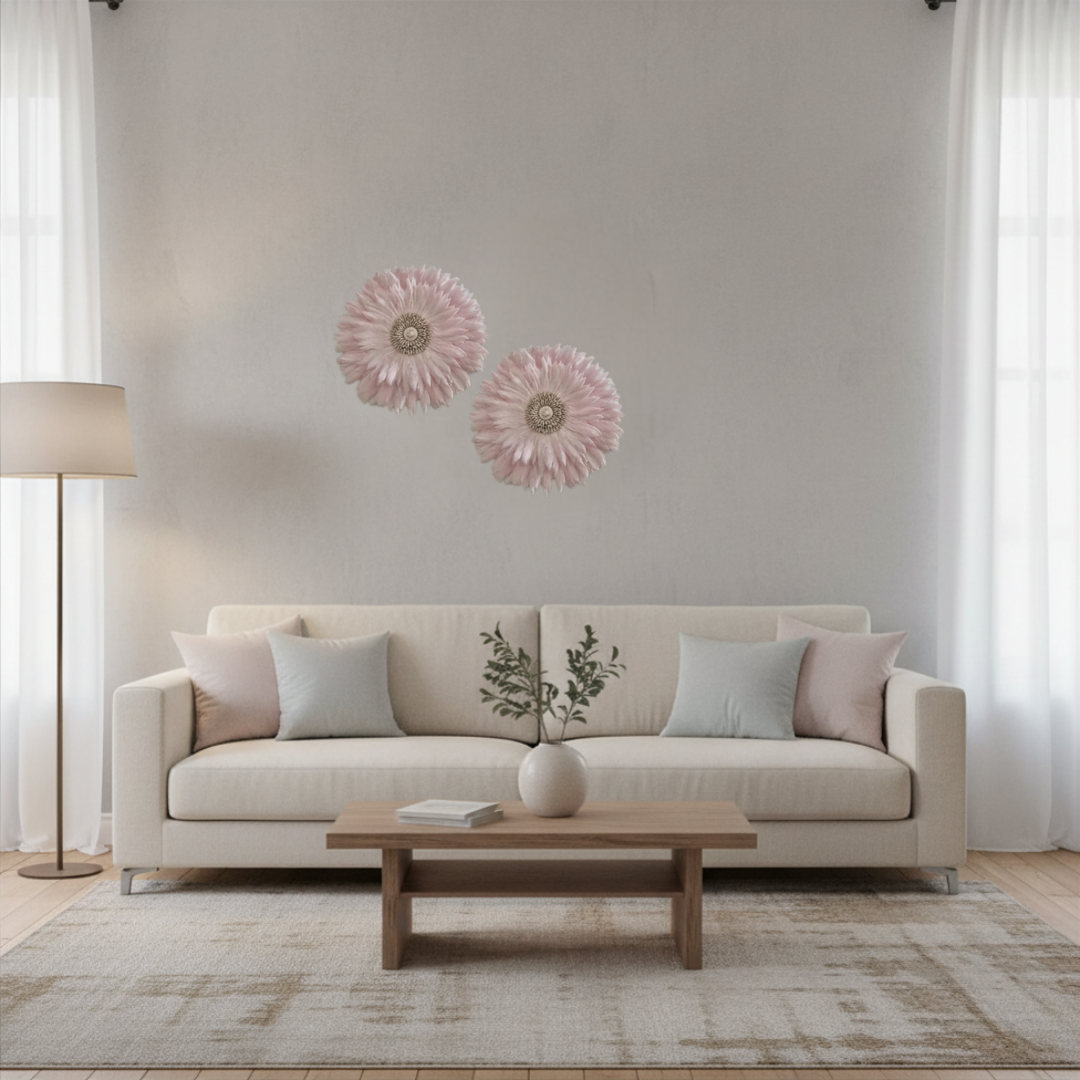 Two pink feathered JUJU hats grouped together above a cream sofa in a bright minimal living room with sheer curtains and timber coffee table 35x35cm