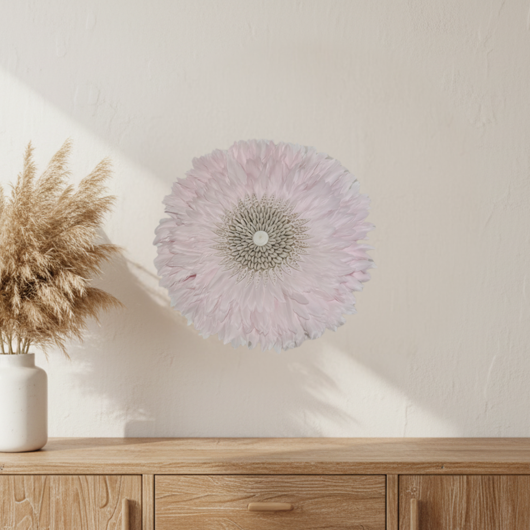 Pink JUJU hat wall art displayed above a timber sideboard with dried pampas grass in a white ceramic vase on a warm white wall