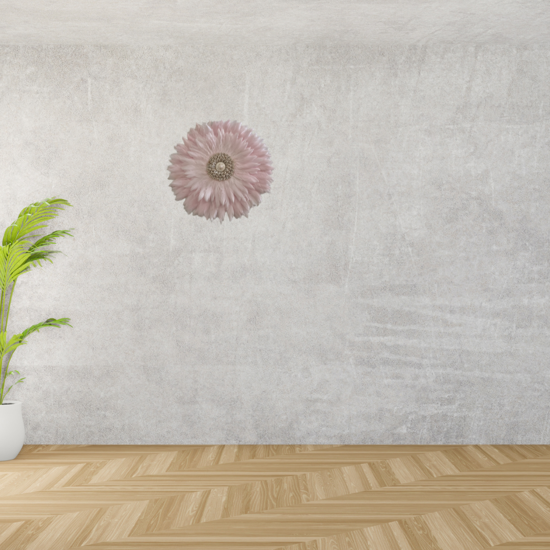 Decorative pink flower on a textured wall with a plant on a wooden floor.