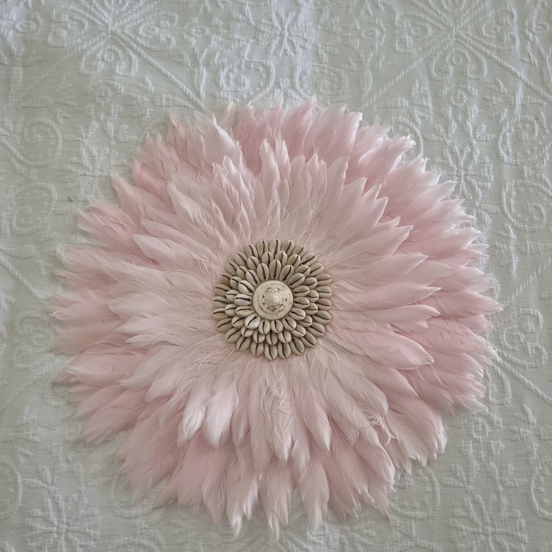 Pink feathered flower decoration on a textured light gray background